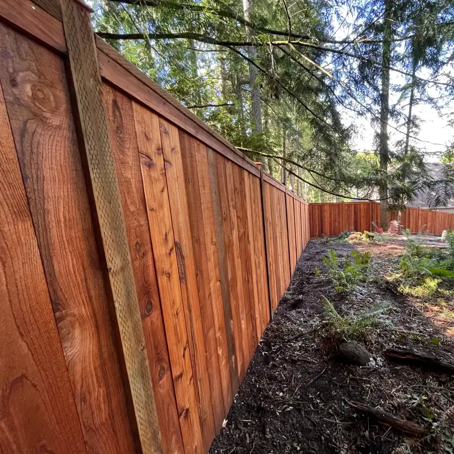 Wood privacy fence along a wooded yard