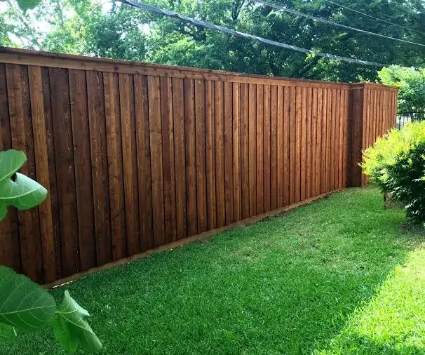 Stained wood fence beside a lawn