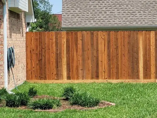 New wood fence next to a brick home