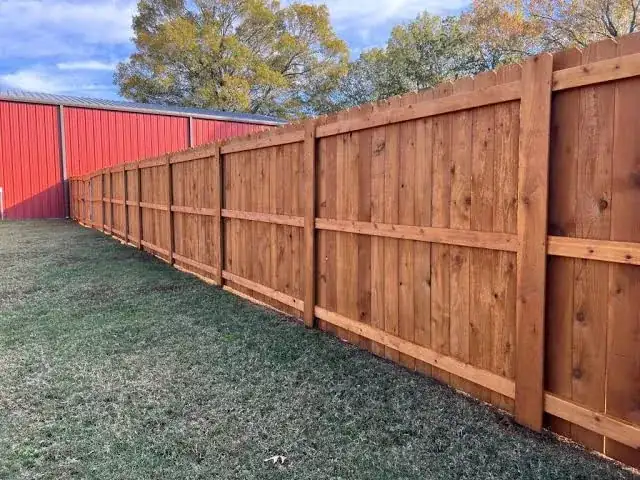 Stained wood fence beside a metal building